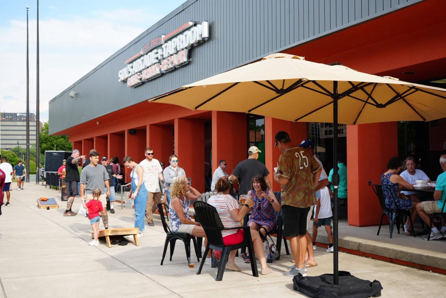Outside view of Sol's Arcade + Taproom in Fayetteville NC with guests on the patio